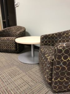 Brown office chairs and modern end tables sit on new carpet installation