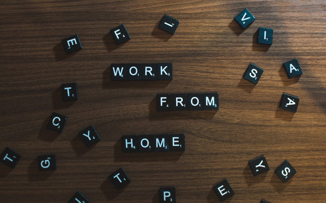 the words "work from home" spelled out in black tiles against a wood background