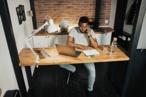 man working from home at wooden desk