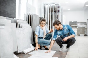 a man and a woman looking at ceramic flooring in a store