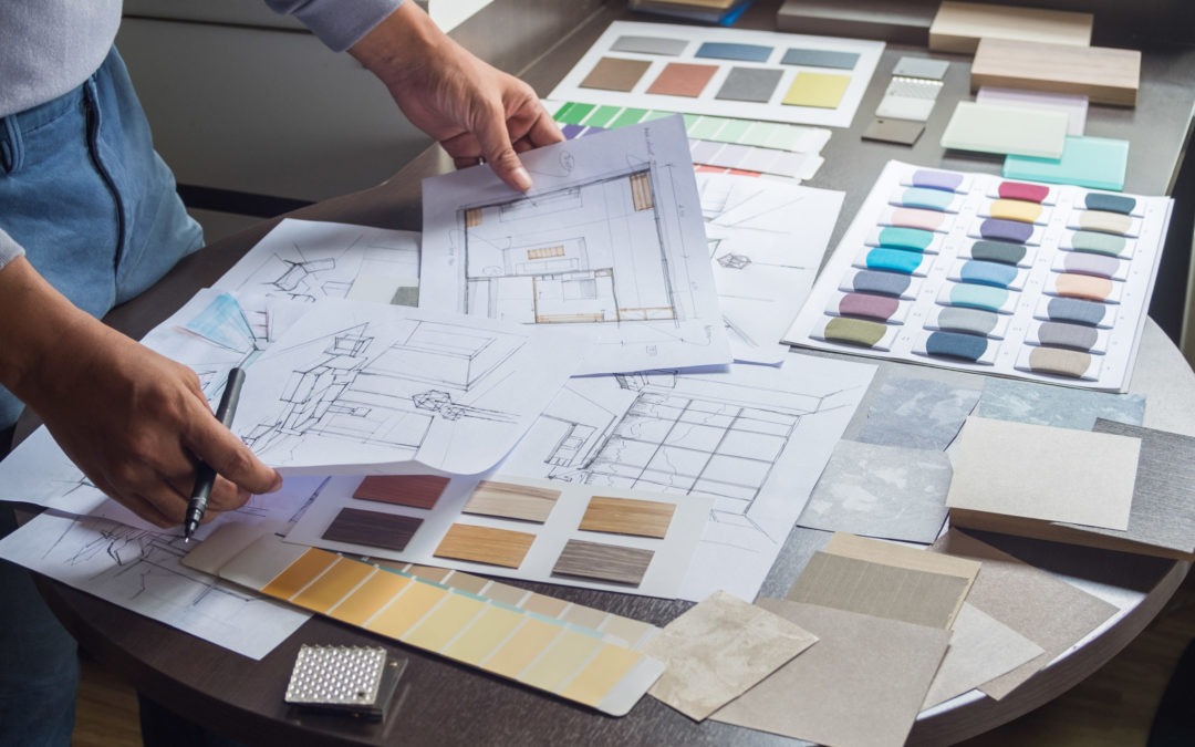 interior designer looking at Commercial interior Design plans laid out on table