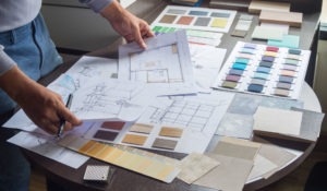 interior designer looking at Commercial interior Design plans laid out on table