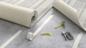 process of carpet installation shown with beige carpet on floor with tape measure, knife, and stapler