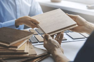 a customer sitting at a table with commercial hardwood flooring vendor looking at samples of hardwood flooring