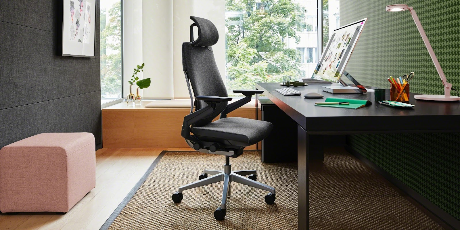 steelcase gesture chair with headrest. dark gray color. placed in front of a desk.