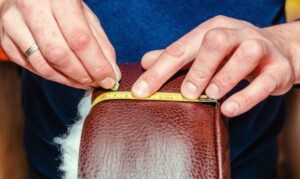 Seat upholstery in a furniture workshop, eco-leather cover, close-up of hands repairing leather furniture