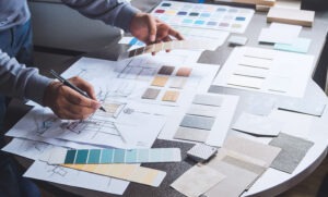 Architect designer Interior creative working hand drawing sketch plan blue print selection material color samples art tools to help find the perfect office color schemes