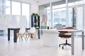 office layout idea with shared workspaces, a white board, private desk, office storage, plants, and natural light