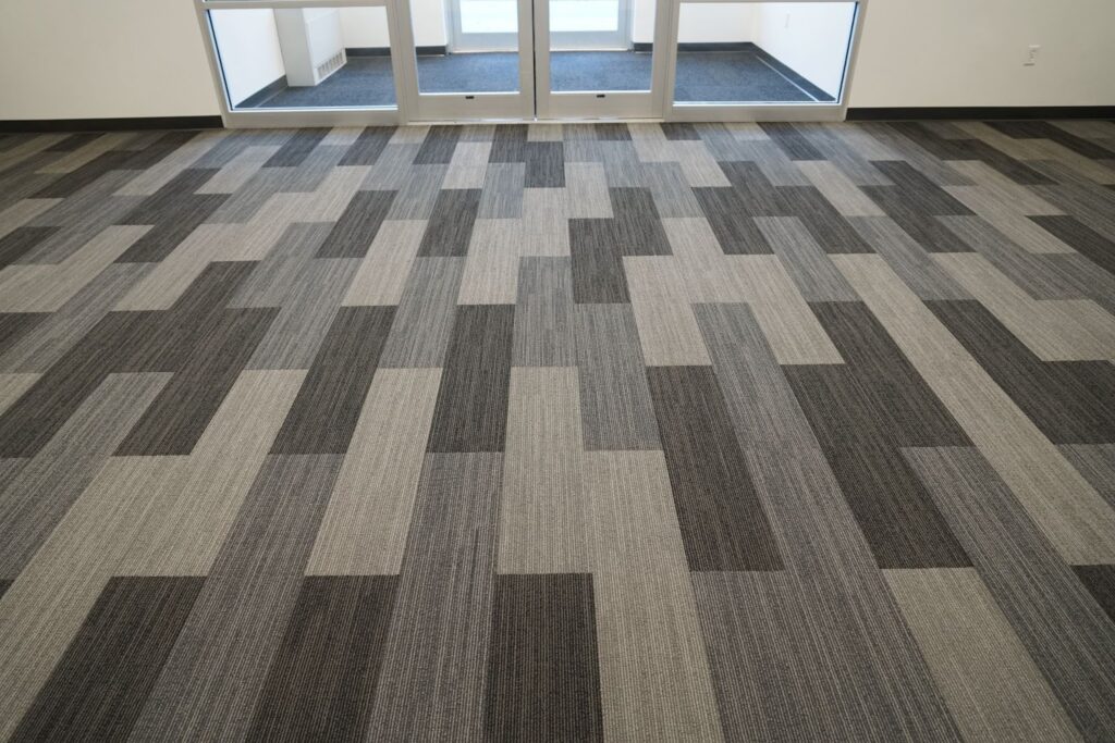 view of commerical carpeting installed in the entry way of a business. the carpet is various shades of gray showing the flooring trend