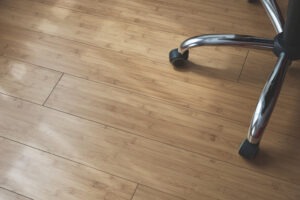 wheels of an office chair on a hard wood floor that is on trend with flooring trends