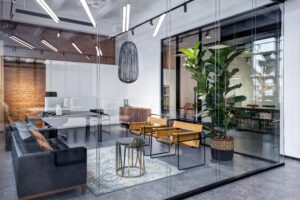 Interior meeting room in modern space office with a brick walls and wooden computer desks. View through glass partition showing office furniture trends